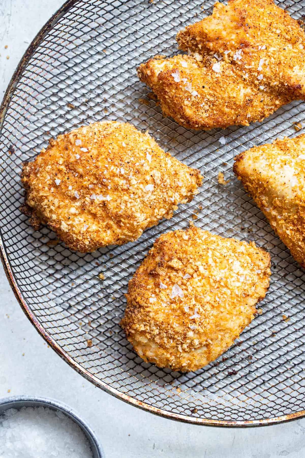Crispy Breaded Air Fryer Chicken Breast - SO crispy you won't believe how healthy and easy it is to make! Great for busy weeknights and for picky eaters! There is a gluten free option included! | #Foodfaithfitness | #Glutenfree #Healthy #Kidfriendly #Airfryer #Nutfree chicken breast in the air fryer cooked on a basket