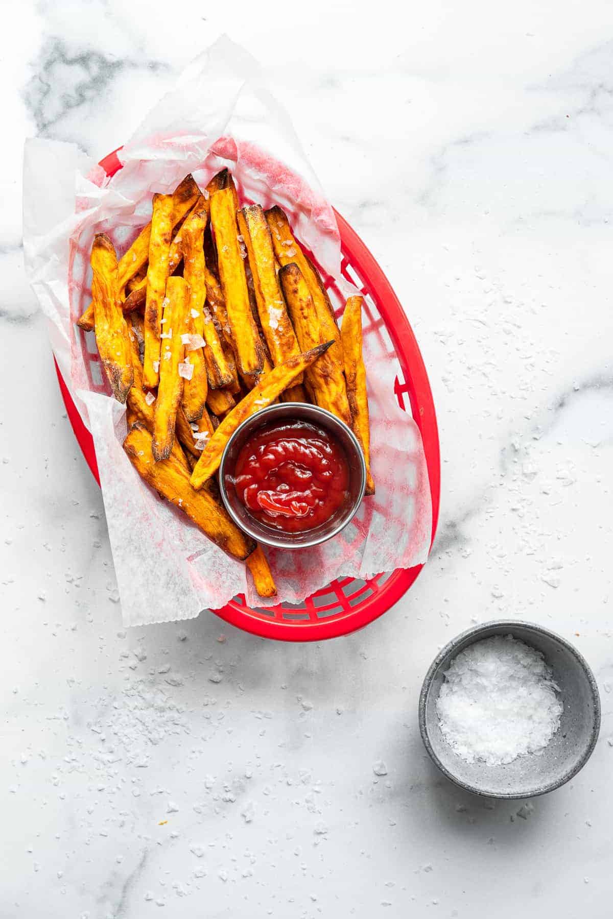 Air Fryer Sweet Potato Fries - These Air Fryer Sweet Potato Fries are only 3 simple ingredients and are so crispy! Naturally gluten free, vegan, paleo & whole30 too! | #Foodfaithfitness | #Glutenfree #paleo #vegan #whole30 #healthy air fryer sweet potato fries in a basket with ketchup