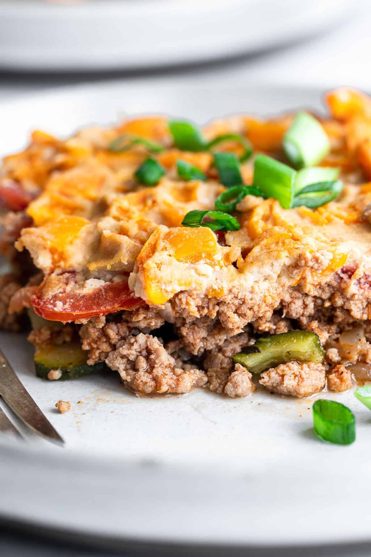 Dairy Free Paleo Casserole - This easy, gluten free and low carb chicken casserole is made of layers of fresh veggies, bright herbs and chicken! Naturally gluten free, whole30 and so delicious! | #Foodfaithfitness | #Glutenfree #Healthy #Whole30 #Lowcarb #Keto close of dairy free paleo chicken casserole on a plate