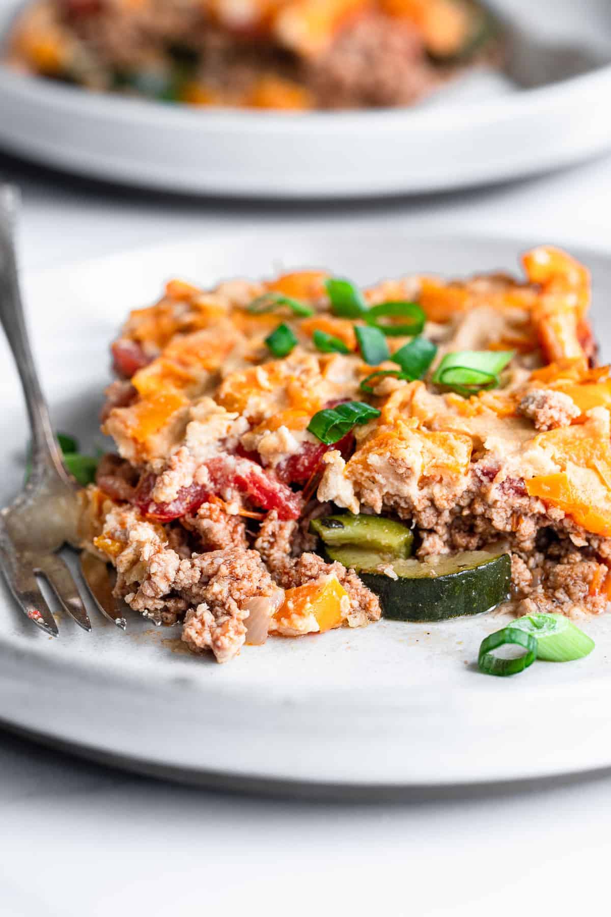 Dairy Free Paleo Casserole - This easy, gluten free and low carb chicken casserole is made of layers of fresh veggies, bright herbs and chicken! Naturally gluten free, whole30 and so delicious! | #Foodfaithfitness | #Glutenfree #Healthy #Whole30 #Lowcarb #Keto dairy free paleo chicken casserole with a bite taken out of it