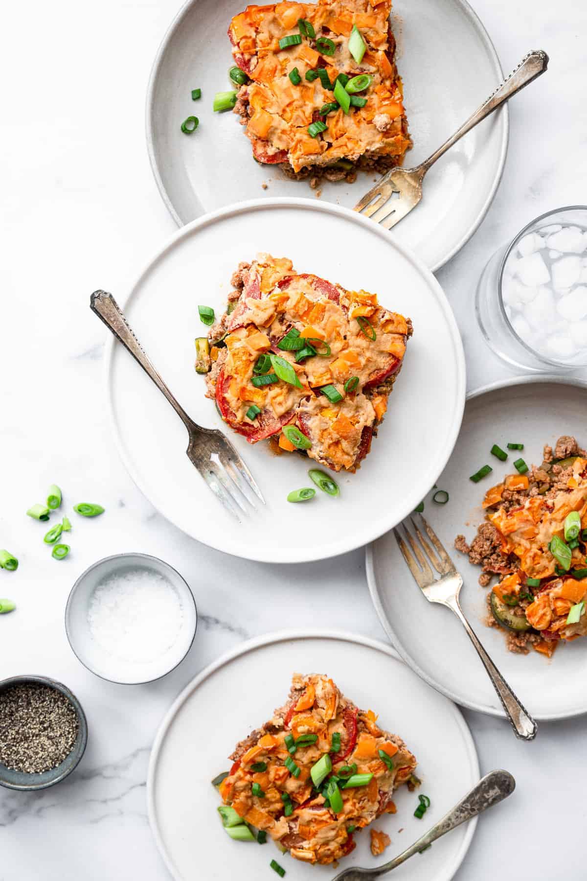 Dairy Free Paleo Casserole - This easy, gluten free and low carb chicken casserole is made of layers of fresh veggies, bright herbs and chicken! Naturally gluten free, whole30 and so delicious! | #Foodfaithfitness | #Glutenfree #Healthy #Whole30 #Lowcarb #Keto paleo chicken casserole on 3 plates stacked on top of each other