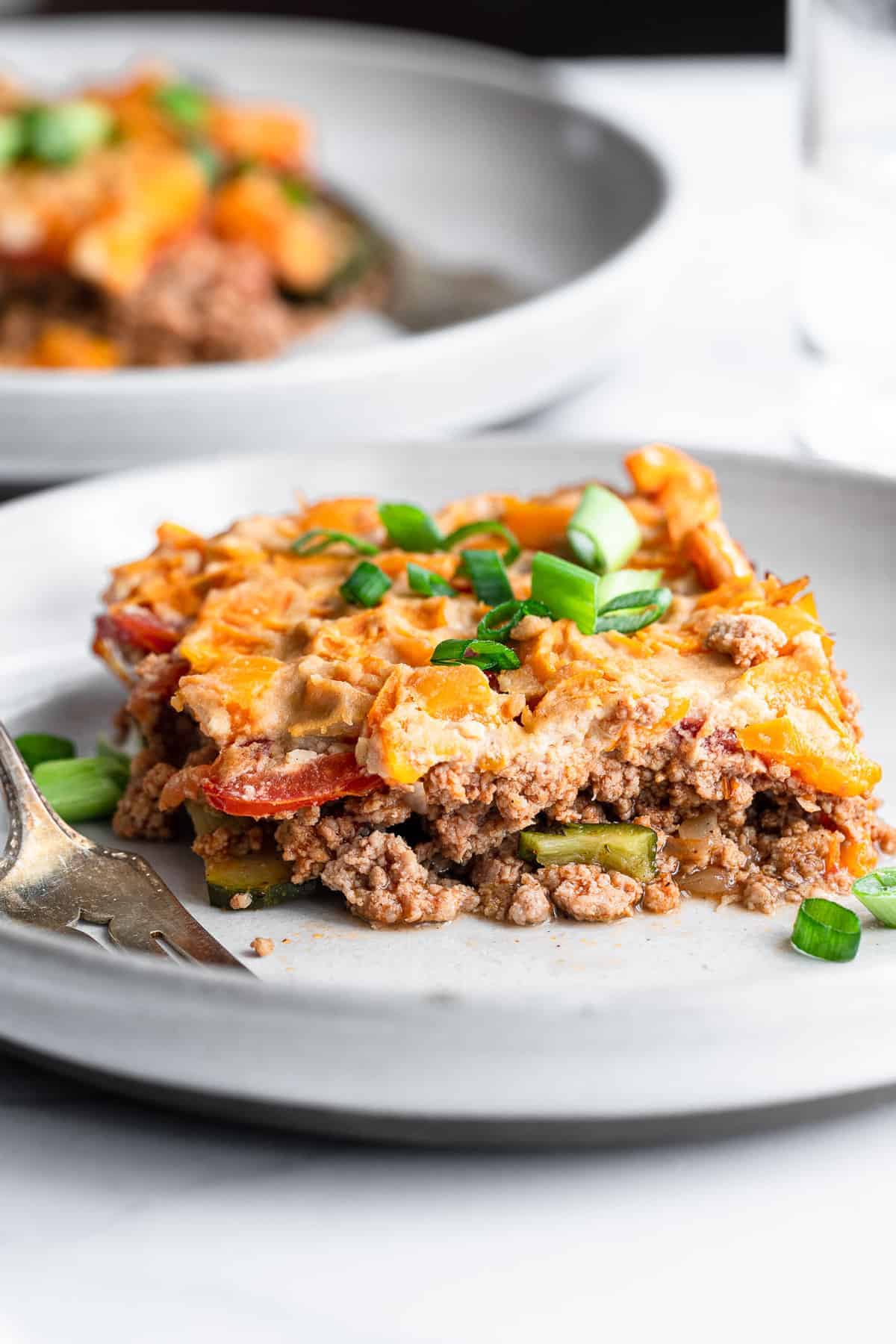 Dairy Free Paleo Casserole - This easy, gluten free and low carb chicken casserole is made of layers of fresh veggies, bright herbs and chicken! Naturally gluten free, whole30 and so delicious! | #Foodfaithfitness | #Glutenfree #Healthy #Whole30 #Lowcarb #Keto whole30 casserole on plate