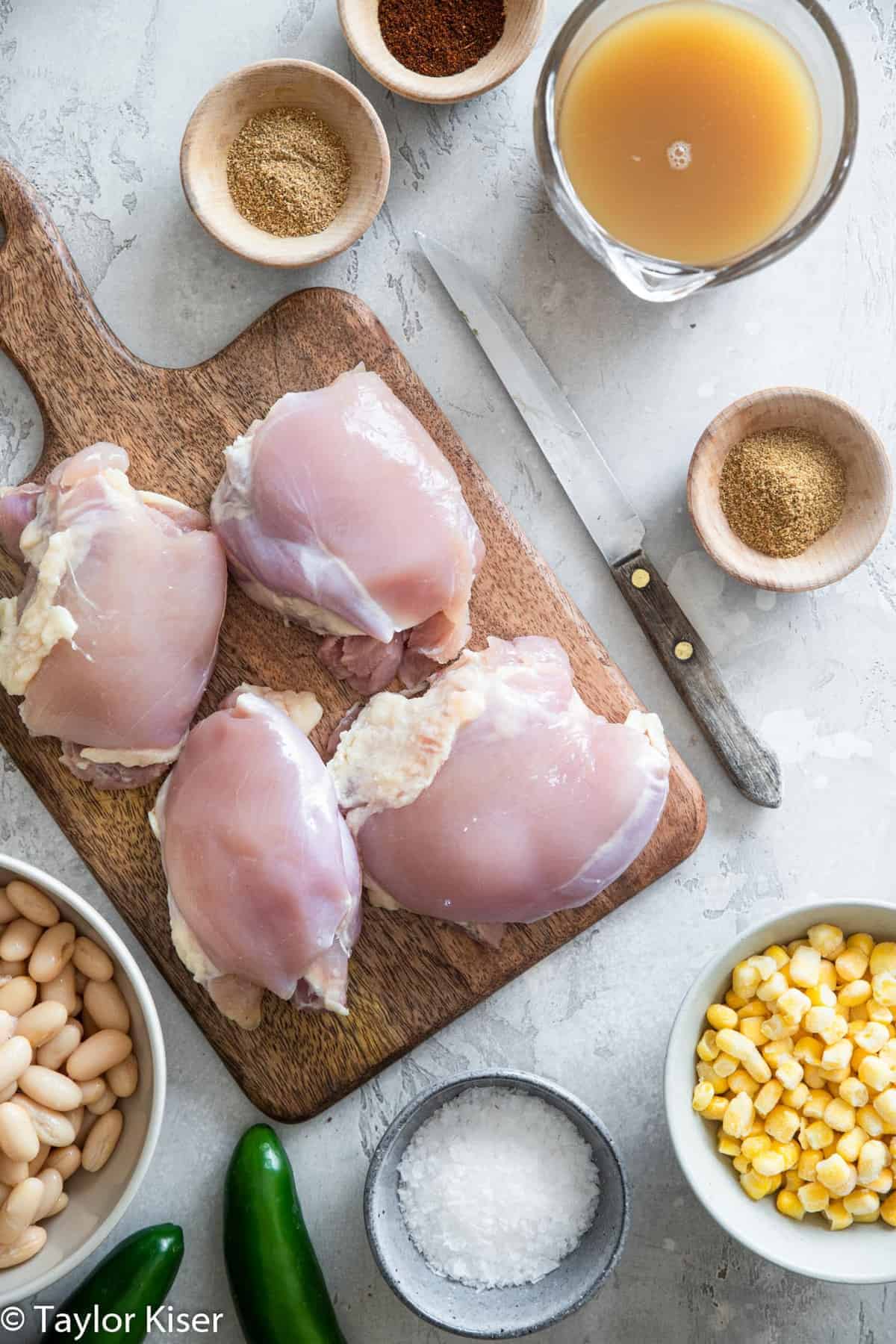 Healthy White Chicken Chili - This chicken chili is cooked in the crockpot for an easy, weeknight dinner that is naturally gluten and dairy free, simple and so tasty! Great for the whole family! | #Glutenfree #dairyfree #healthy #crockpot #soup chicken breasts on a cutting board for Crockpot White Chicken Chili