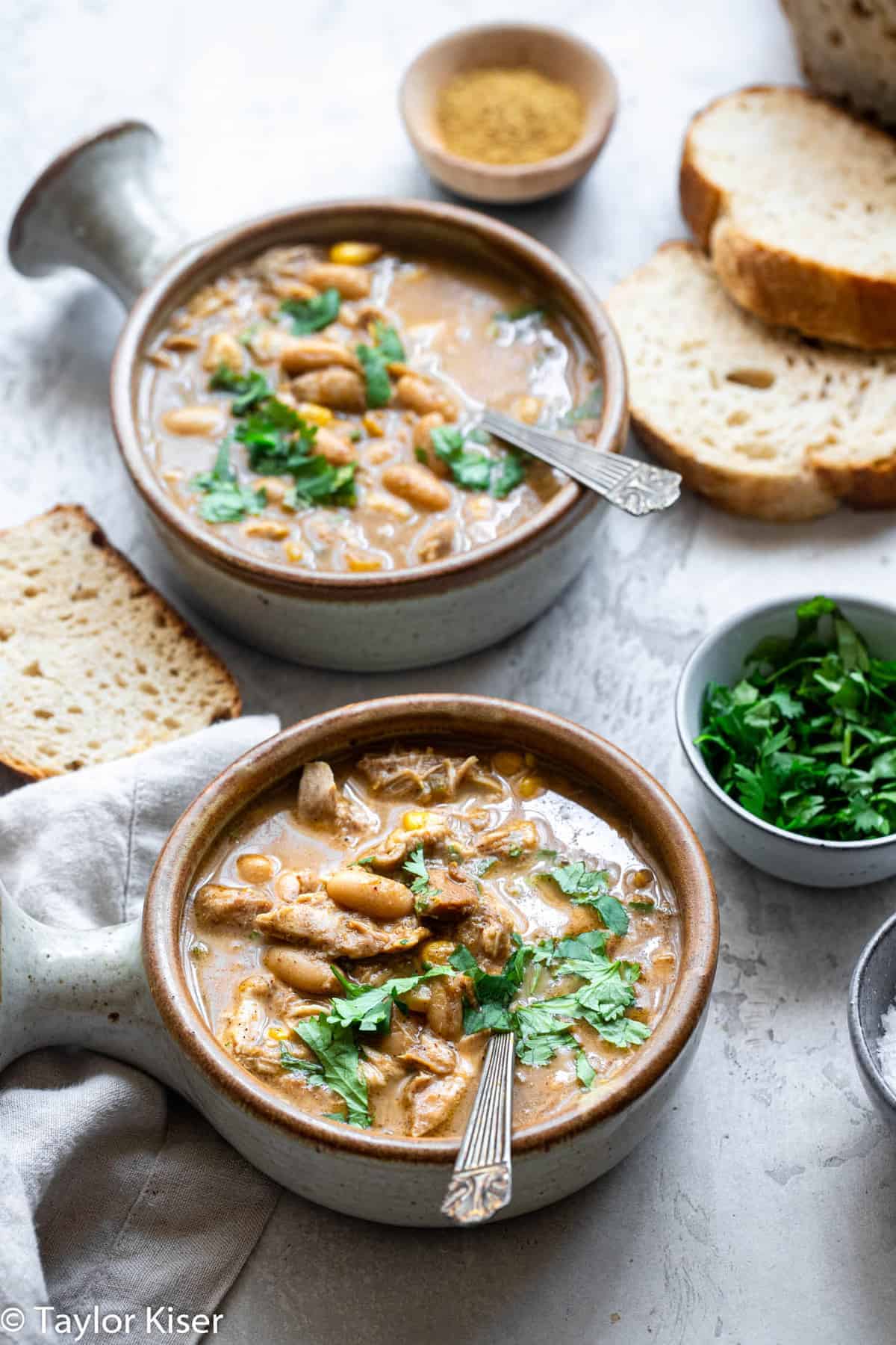 Healthy White Chicken Chili - This chicken chili is cooked in the crockpot for an easy, weeknight dinner that is naturally gluten and dairy free, simple and so tasty! Great for the whole family! | #Glutenfree #dairyfree #healthy #crockpot #soup 2 bowls of Crockpot White Chicken Chili on a table