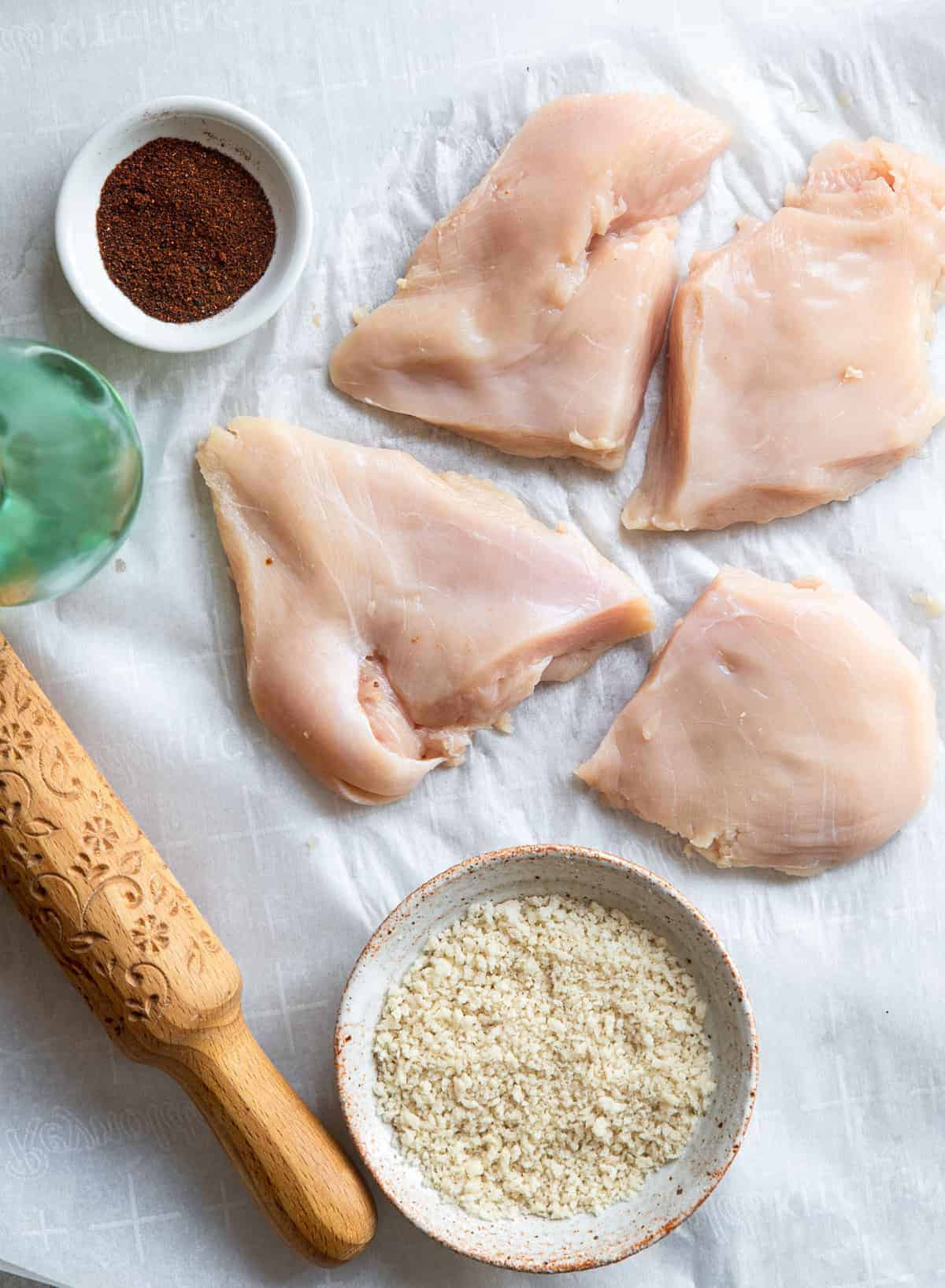 Crispy Breaded Air Fryer Chicken Breast - SO crispy you won't believe how healthy and easy it is to make! Great for busy weeknights and for picky eaters! There is a gluten free option included! | #Foodfaithfitness | #Glutenfree #Healthy #Kidfriendly #Airfryer #Nutfree raw chicken being flattened for Air Fryer Breaded Chicken Breast