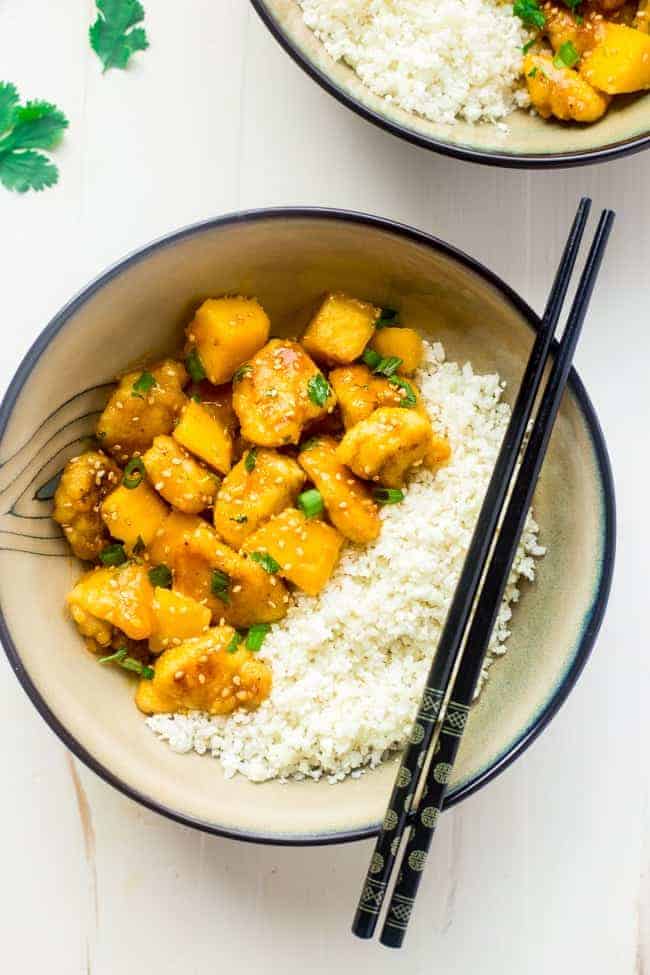 Mango Chicken with Coconut Cauliflower Rice - This paleo mango chicken is served over coconut cauliflower rice for a quick, easy and healthy spin on take-out that is ready in 30 mins! Recipe has a vegan option too! | Foodfaithfitness.com | @FoodFaithFit