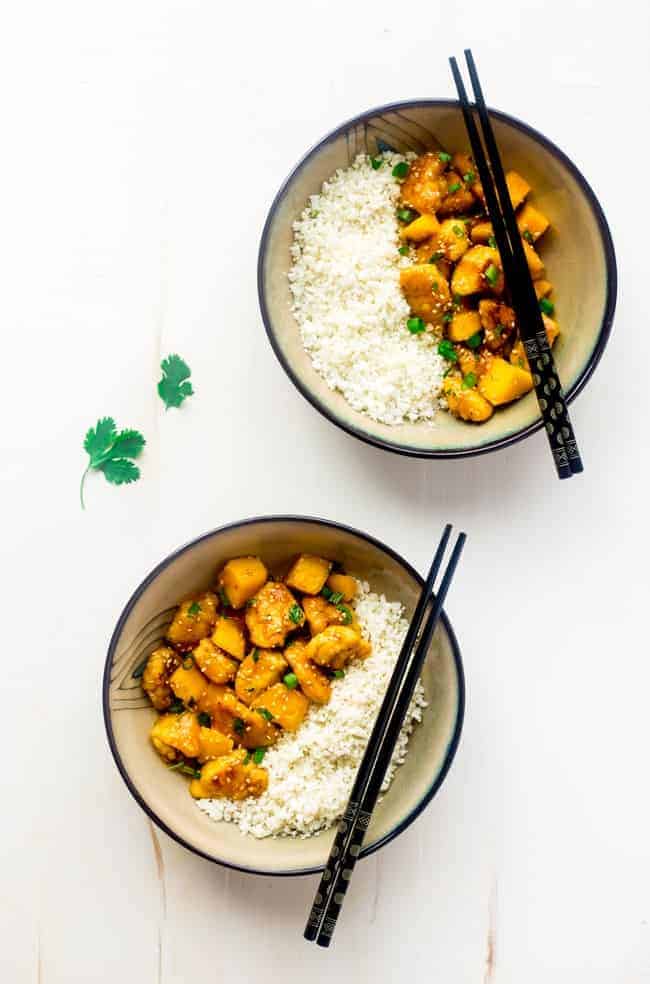 Mango Chicken with Coconut Cauliflower Rice - This paleo mango chicken is served over coconut cauliflower rice for a quick, easy and healthy spin on take-out that is ready in 30 mins! Recipe has a vegan option too! | Foodfaithfitness.com | @FoodFaithFit