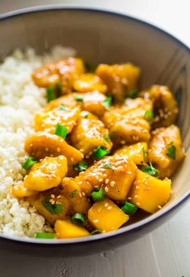 Mango Chicken with Coconut Cauliflower Rice - This paleo mango chicken is served over coconut cauliflower rice for a quick, easy and healthy spin on take-out that is ready in 30 mins! Recipe has a vegan option too! | Foodfaithfitness.com | @FoodFaithFit