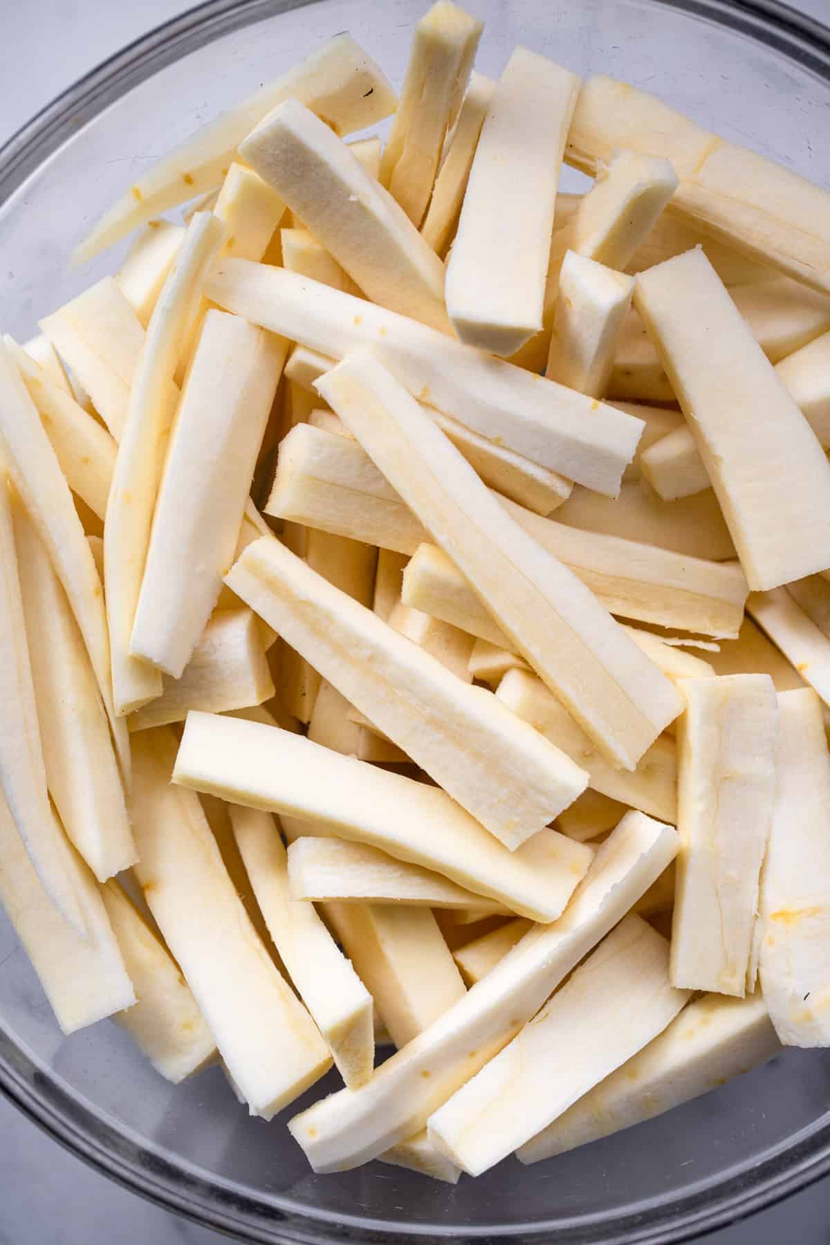 Parsnip Fries - These parsnip fries are baked, not fried, but are still crispy and delicious! A healthy alternative to French fries that is naturally gluten free and tasty! Only a few ingredients too! | #Foodfaithfitness | #Glutenfree #paleo #healthy #vegan #dairyfree Parsnip Fries cut and ready to be bakes