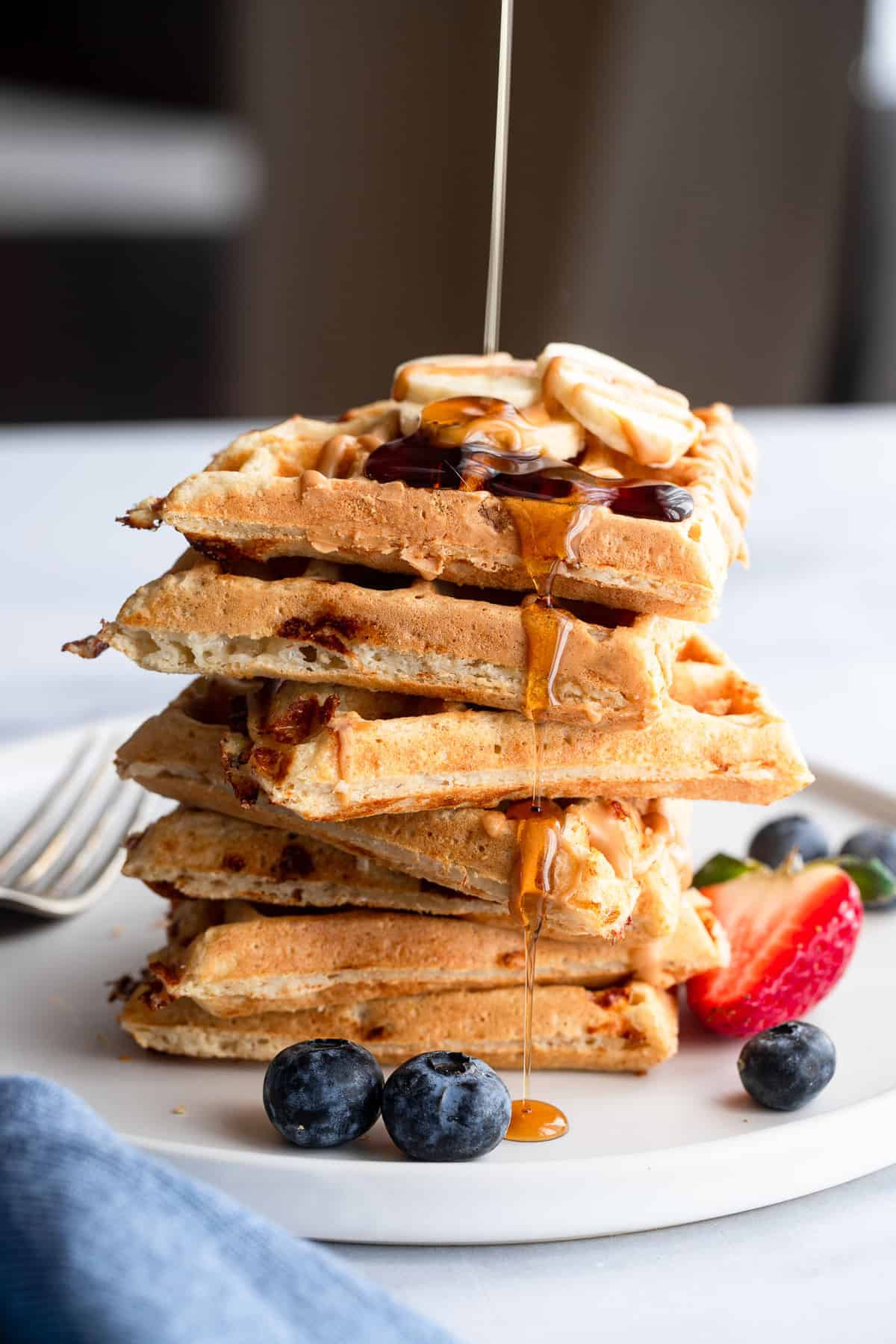 Easy Protein Waffles - These are the crispiest, fluffiest protein waffles you will ever eat! Naturally gluten free, quick, easy and so filling! A MUST MAKE. | #Foodfaithfitness | #glutenfree #healthy #waffles #breakfast a stack of protein waffles drizzled with maple syrup