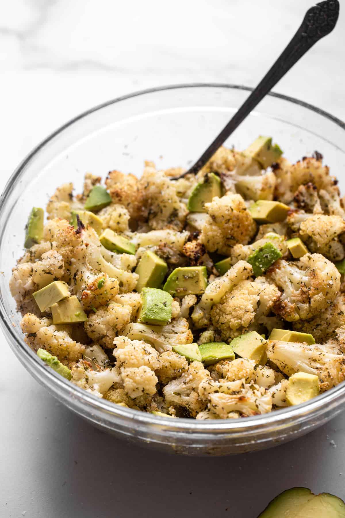 Parmesan Roasted Ranch Cauliflower - This healthy and keto friendly Parmesan Roasted Ranch Cauliflower is flavored with Parmesan, ranch seasoning and toss with avocado for a SUPER easy side dish that is kid friendly! | #Foodfaithfitness | #glutenfree #keto #lowcarb #heathy ranch cauliflower in a bowl with a spoon