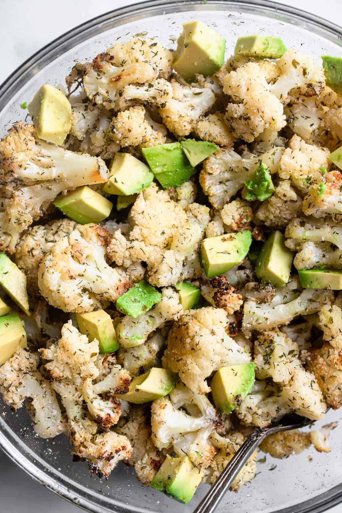 Parmesan Roasted Ranch Cauliflower - This healthy and keto friendly Parmesan Roasted Ranch Cauliflower is flavored with Parmesan, ranch seasoning and toss with avocado for a SUPER easy side dish that is kid friendly! | #Foodfaithfitness | #glutenfree #keto #lowcarb #heathy extreme close up of ranch cauliflower in a bowl