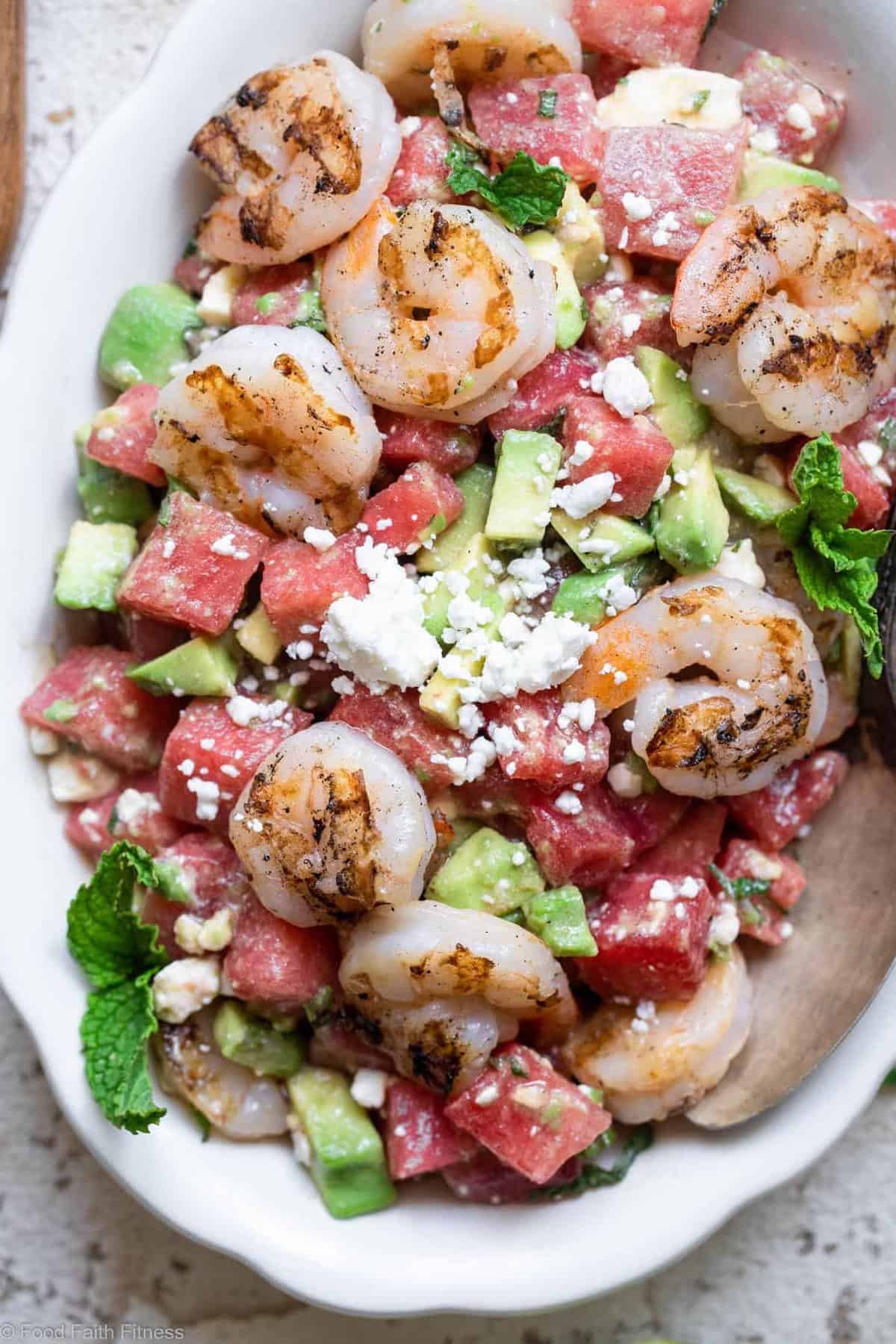 Shrimp Avocado Salad with Watermelon - An easy, healthy Summer dinner that is light and refreshing! Naturally gluten free, protein packed, under 300 calories and SO tasty! | #Foodfaithfitness | #Glutenfree #healthy #grainfree #watermelonĀ Close up photo of a bowl filled with shrimp avocado salad with watermelon